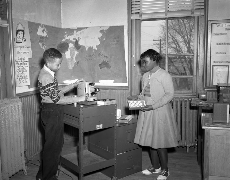 Students operate filmstrip projector in classroom, ca. 1958 (Image from Flickr: Library of Virginia, Prints and Photographs Archive)