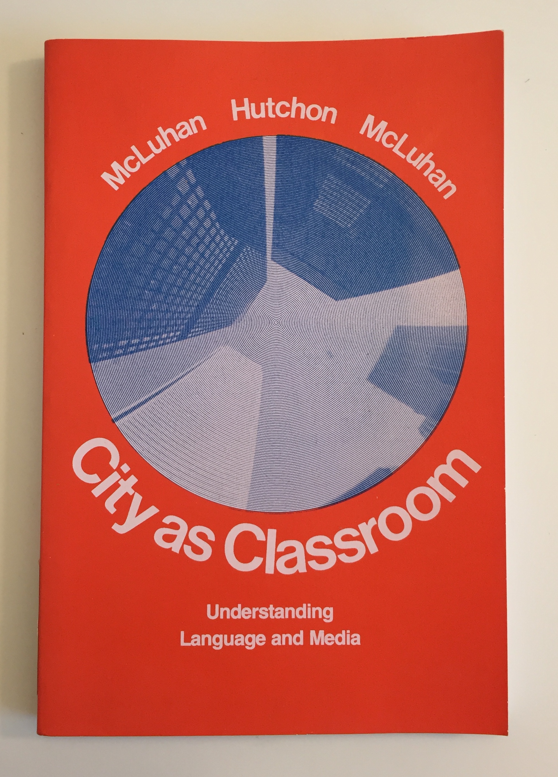 Cover of City as Classroom textbook, orange background with circular grey skyscraper image